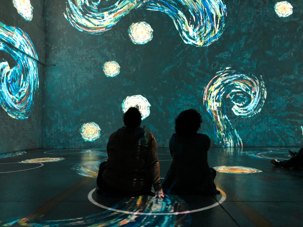 Two people facing an interactive art exhibit